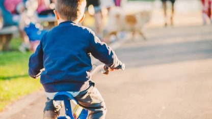 Malý kluk jede na dětském kole