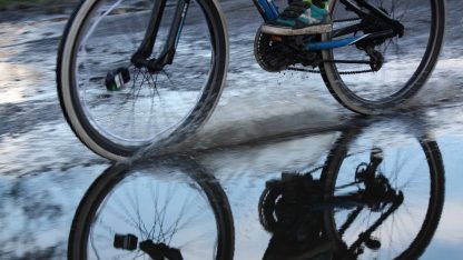 Kolo bez blatníků projíždějící louží