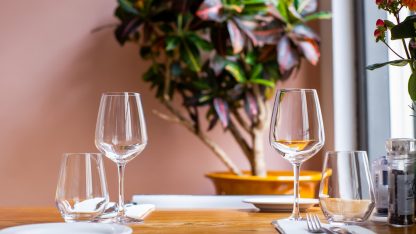 Prostřený stůl se skleničkami na bílé víno