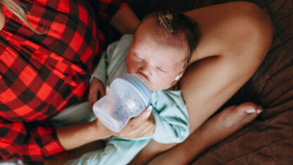 kojenec pije méko z dětské lahve